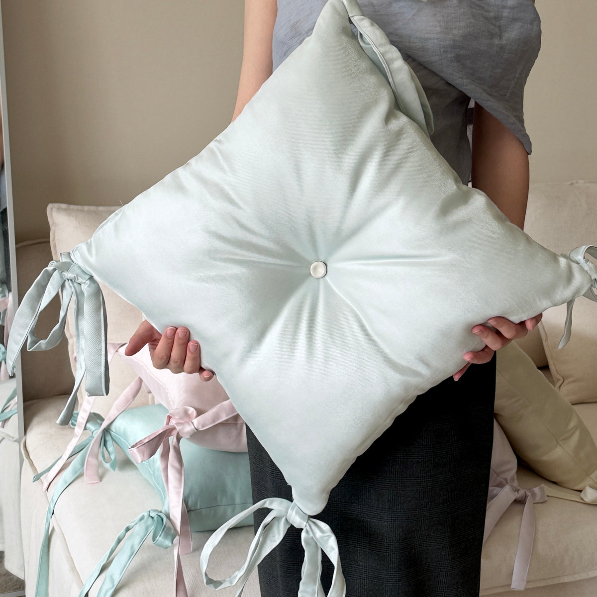 Close-up of a ceramic button and satin cushion detail